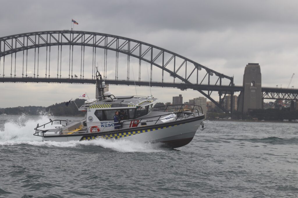 Marine Rescue NSW offshore response vessel with Seakeeper Ride installed, in front of the Sydney Harbour Bridge. 