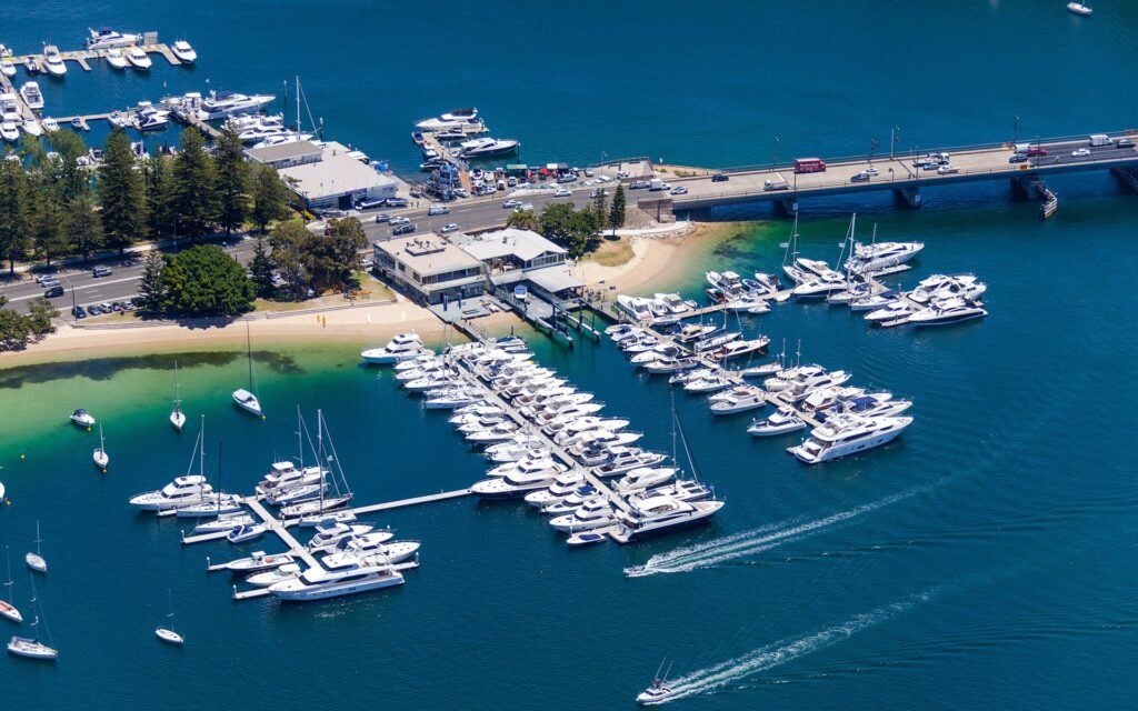 Birdseye view of Oceantec Marine, surrounded by the ocean, boats and yachts, on a sunny day. 